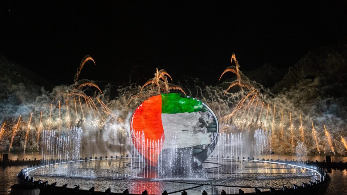 The sculpture showing the UAE flag, ringed by water fountains and gold pyrotechnic fans.