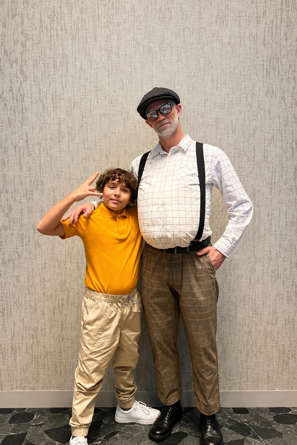 The two performers posed together backstage against a plain wall, in costume.