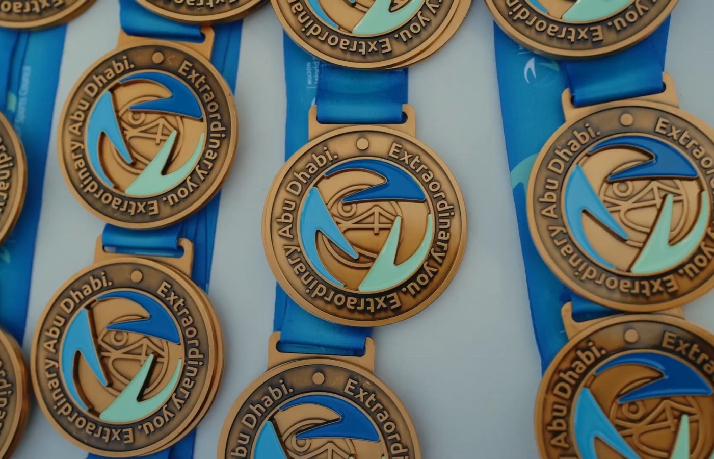 Finisher medals on blue ribbons laid out side by side.